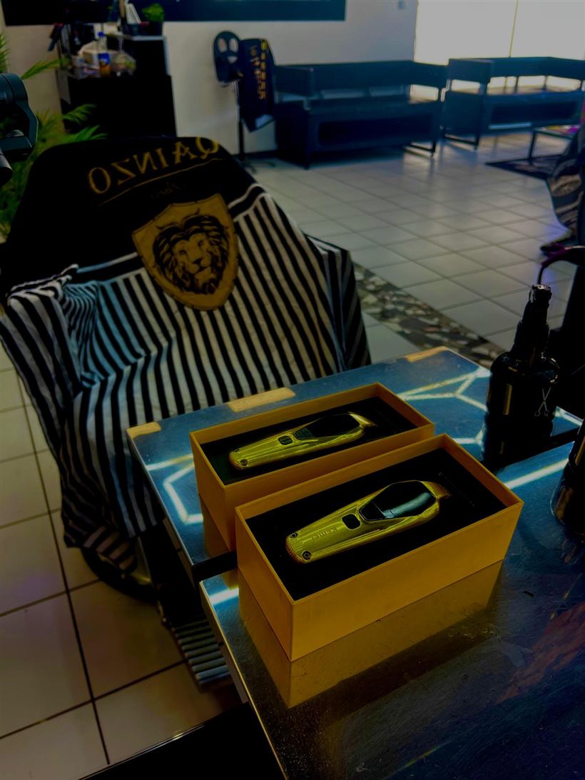 Deux tondeuses dorees sans fil dans leur coffret, sur le poste de coiffure